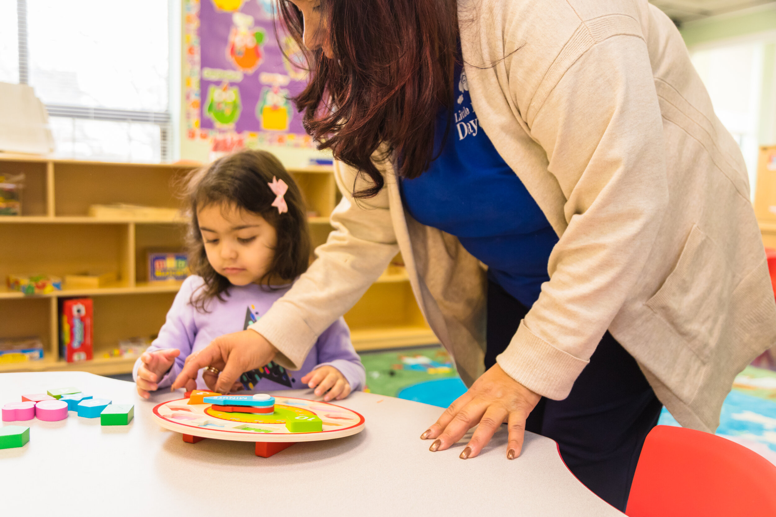 image of woman helping a little girl stock blocks